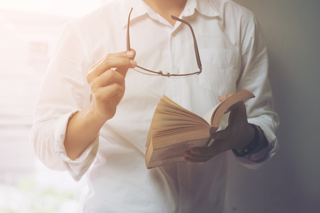 Homme d&#39;affaires en lisant un livre dans une bibliothèque