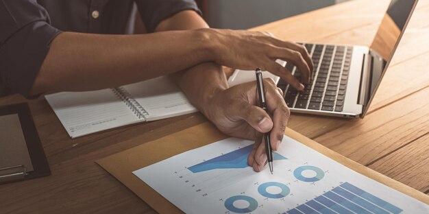 Photo l'homme d'affaires lit un graphique mensuel des ventes dans son bureau concept de gestion des ventes