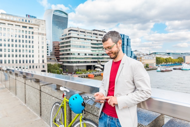 Homme d'affaires à Londres pour se rendre à vélo et taper sur son smartphone