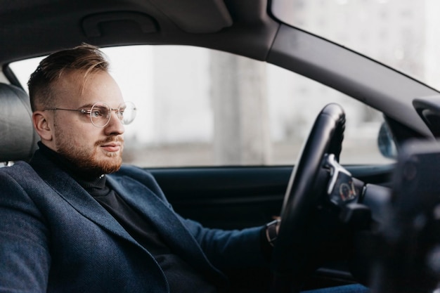 homme d'affaires à lunettes conduit, chauffeur de luxe.