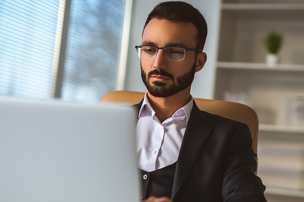 L'homme d'affaires à lunettes travaillant avec un ordinateur portable