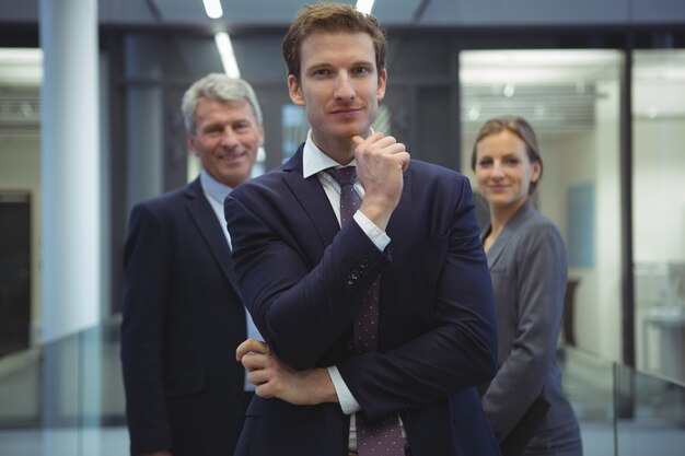 Photo homme d'affaires avec la main sur le menton, debout au bureau