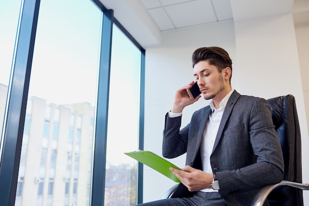 Homme d&#39;affaires avec les mains de documents de parler sur une cellule dans moderne