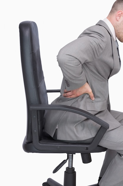 Homme d&#39;affaires avec mal de dos assis dans une chaise de bureau