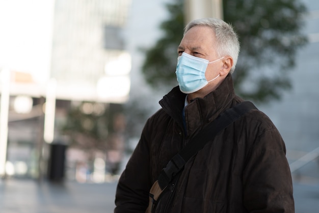 Homme d'affaires masqué marchant en plein air pour aller au travail, concept de mode de vie de personnes coronavirus