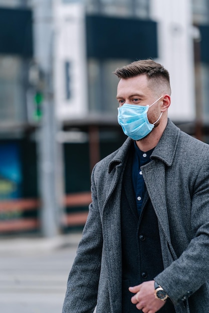 Homme d'affaires avec un masque respiratoire traversant la rue. Fond de feu de circulation. Prévention de l'infection bactérienne Pandémie du virus Corona.