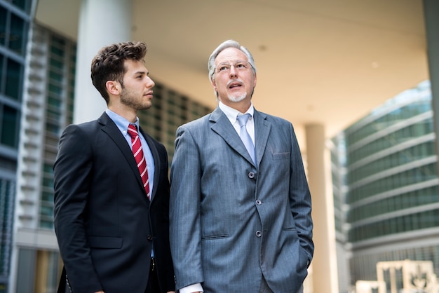 Homme d&#39;affaires mature parlant à un plus jeune devant son bureau