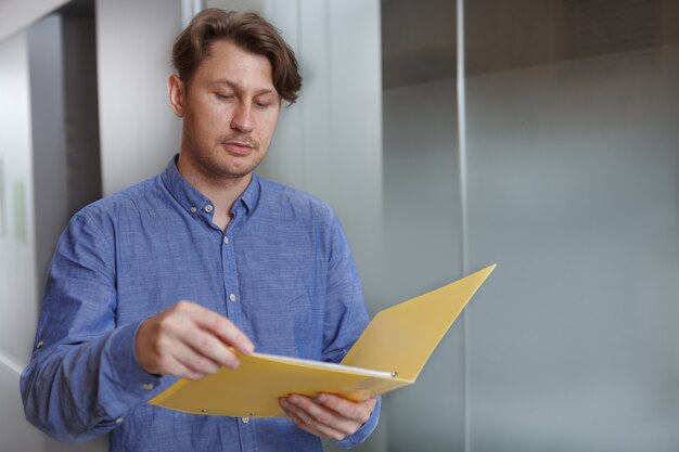 Homme d'affaires mature en passant par les papiers sur son presse-papiers