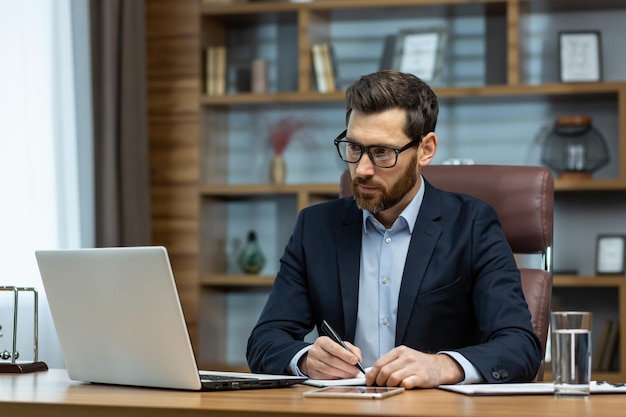 Homme d'affaires mature prospère travaillant à l'intérieur de l'homme de bureau en costume d'affaires travaillant sur le lieu de travail avec