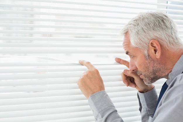 Homme d&#39;affaires mature sérieux furtivement dans le bureau