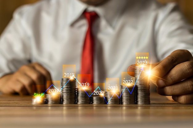 Homme d'affaires mettant des pièces d'argent avec flèche vers le haut et symbole de croissance annuelle pour l'augmentation de la banque de financement