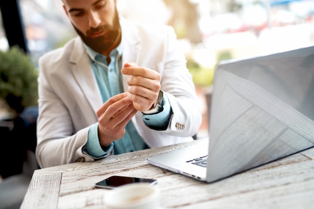 Homme d'affaires mettant en place une montre intelligente à portée de main.