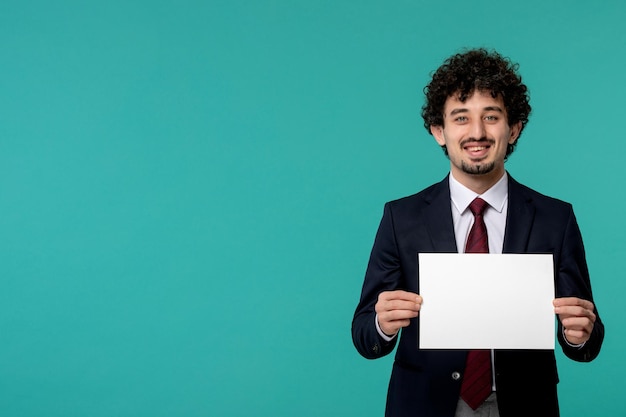 Homme d'affaires mignon joli mec en tenue de bureau noir souriant et tenant une feuille de papier blanc