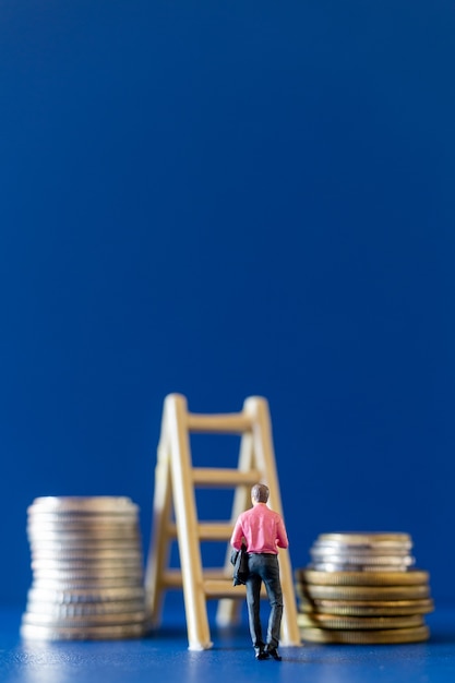 Homme d'affaires miniature avec des pièces de monnaie. Concept de croissance d'entreprise