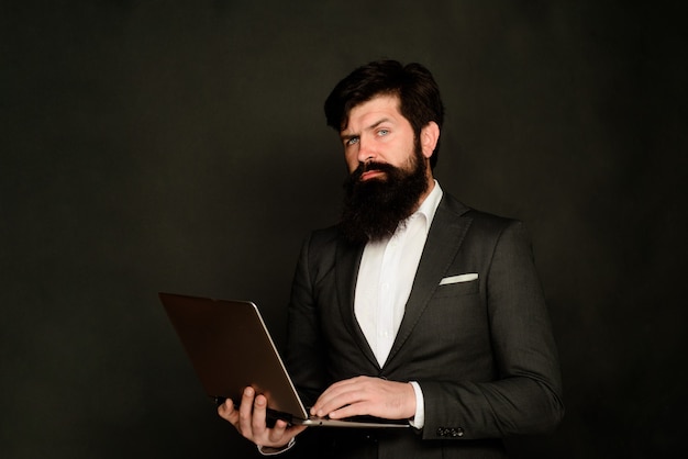 Homme d'affaires avec la mise en réseau de la technologie de l'ordinateur portable et le travail sur Internet au bureau, l'homme sérieux travaille