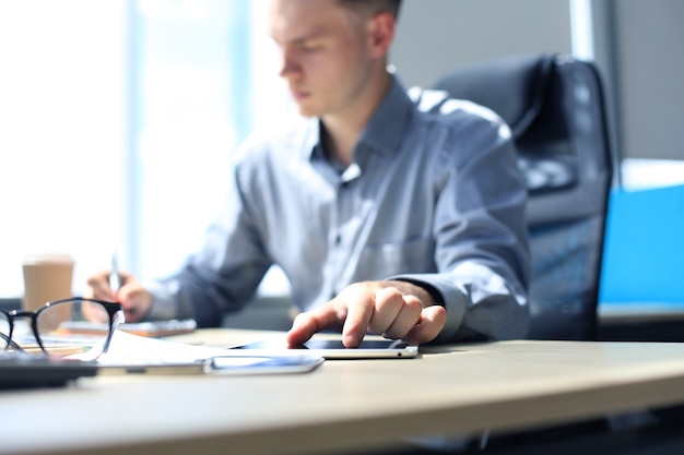 Homme d'affaires moderne analysant les données tout en travaillant au bureau.