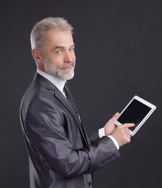 homme d'affaires moderne utilisant une tablette numérique. isolé sur fond noir.