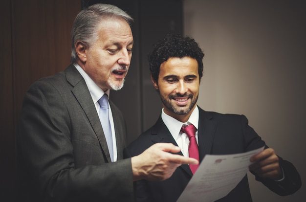 Photo homme d'affaires montrant un document à son collègue