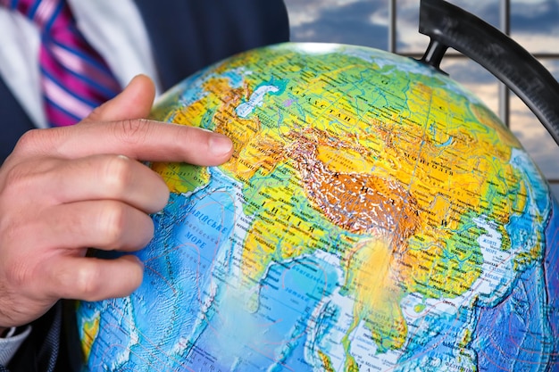 Homme d'affaires montrant le globe à l'homme de jour avec globe à côté de la fenêtre regarder le globe notre maison est fragile