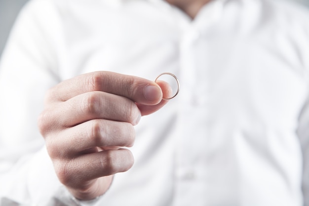 Homme d'affaires montrant sa bague de mariage.