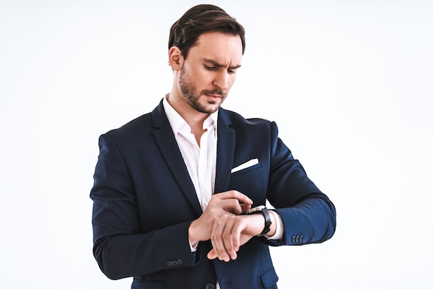 L'homme d'affaires avec une montre debout sur le fond blanc