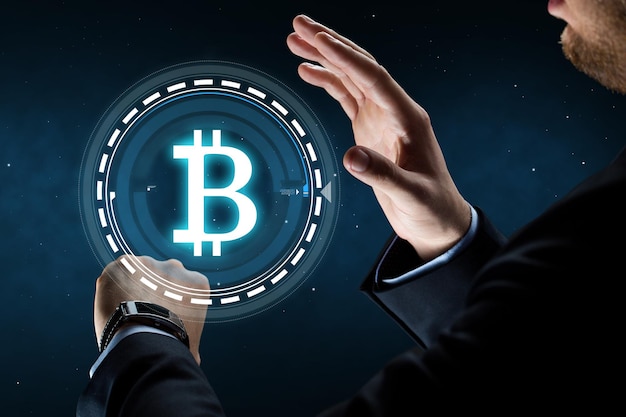 Un homme d'affaires avec une montre intelligente et un hologramme Bitcoin.