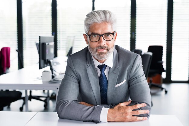 Photo un homme d'affaires mûr en costume gris dans le bureau.