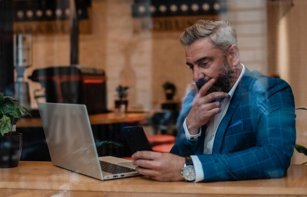 Un homme d'affaires mûr réfléchi pensant à la solution du problème tout en travaillant au bureau