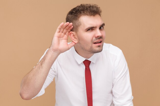 L'homme d'affaires ne vous entend pas. Concept de gens d'affaires, bonnes et mauvaises émotions et sentiments. Studio shot, isolé sur fond marron clair