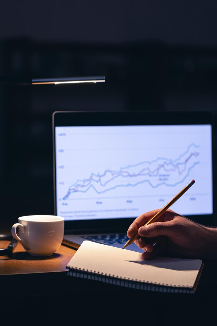 Photo un homme d'affaires, négociant en bourse, regardant l'écran de son ordinateur portable la nuit.