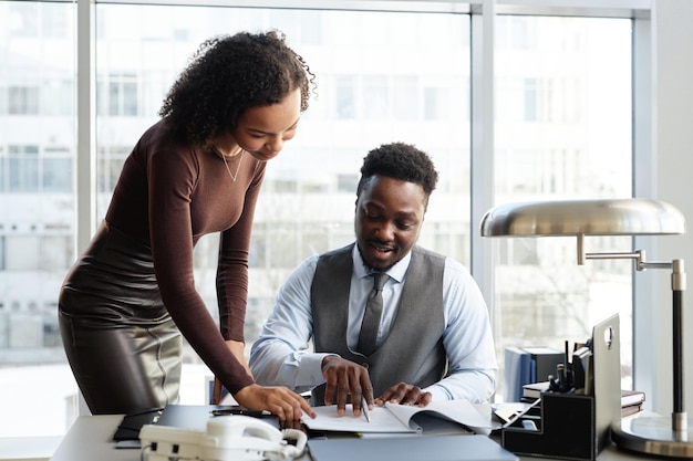 Homme d'affaires noir professionnel avec assistant signant des documents