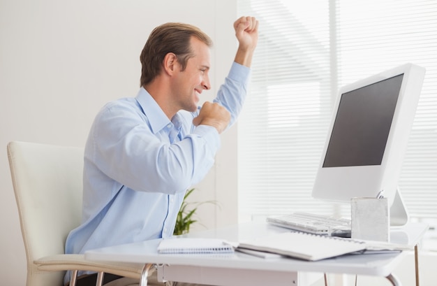 Homme d&#39;affaires occasionnel acclamant à son bureau