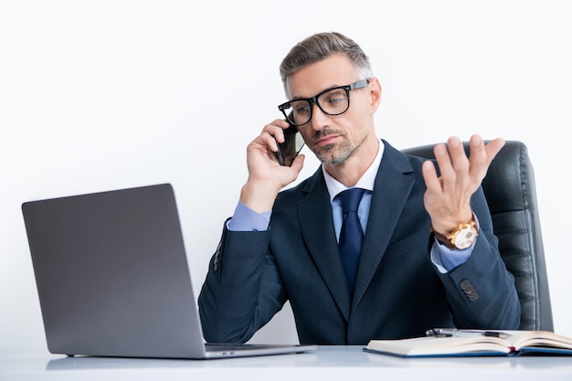 Homme d'affaires occupé à lunettes parlant sur smartphone au bureau avec ordinateur