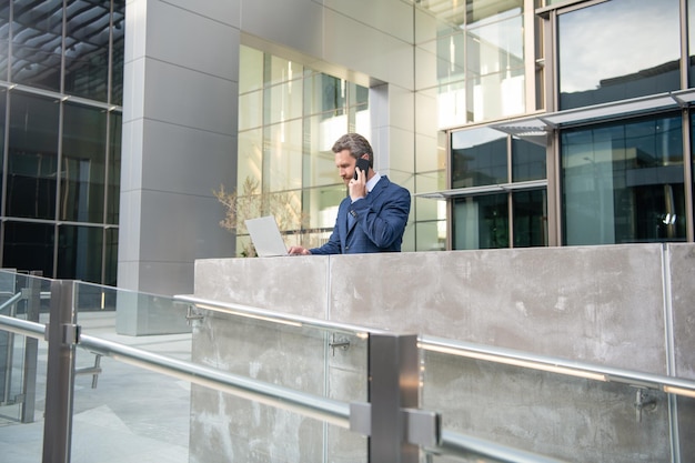 Un Homme D'affaires Occupé En Tenue De Soirée Travaille En Ligne Sur Un Ordinateur à L'aide D'une Communication D'entreprise En Plein Air Par Téléphone