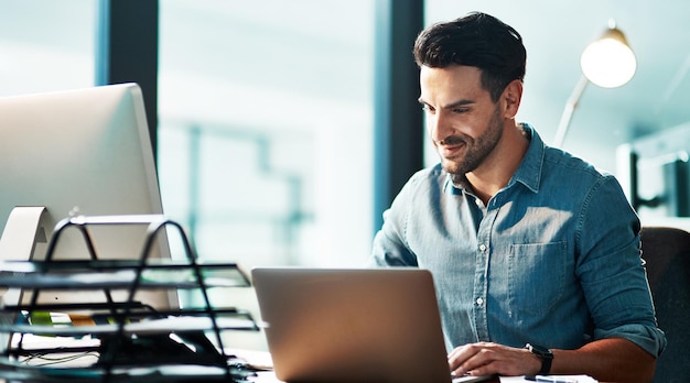 Homme d'affaires avec ordinateur portable travaillant tard dans la nuit, naviguant et recherchant en ligne tout en planifiant la recherche ou en tapant la date limite du bureau Entrepreneur souriant, heureux et confiant, fier du démarrage