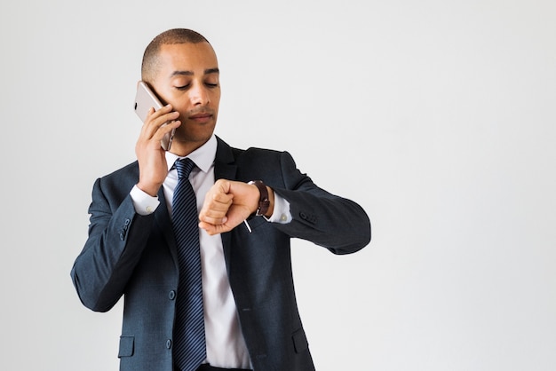 Homme d&#39;affaires parlant à l&#39;appel, vérifiant l&#39;heure du poignet