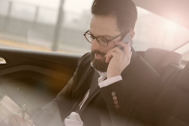 Homme d&#39;affaires parlant au téléphone dans une voiture