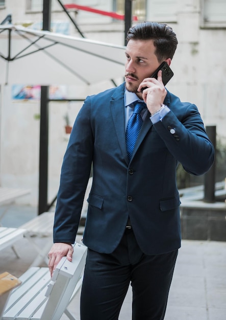 Un homme d'affaires parle au téléphone portable alors qu'il se tient dans un café.