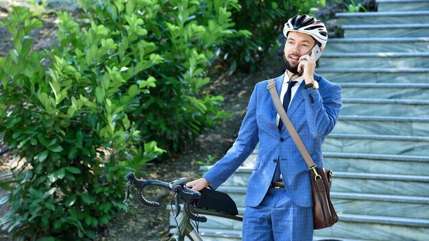 Homme d'affaires, parler au téléphone intelligent avec vélo