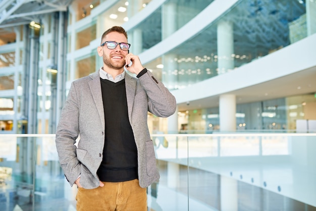 Homme affaires, parler téléphone, dans, immeuble bureau