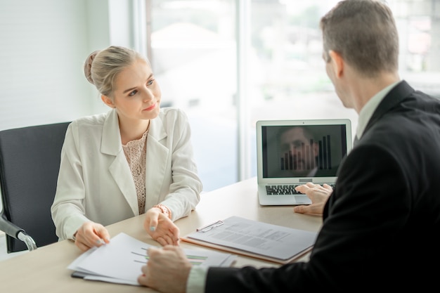 Homme d'affaires patron parler sérieusement de rapport avec une employée au bureau au bureau