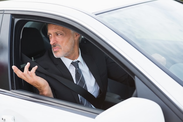 Homme d&#39;affaires perplexe dans le siège du conducteur