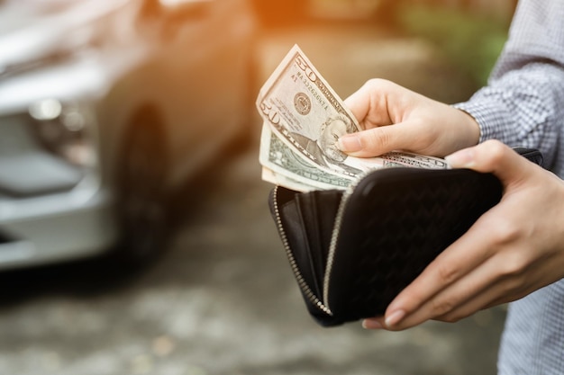 Homme d'affaires Personne tenant un portefeuille dans les mains de prendre de l'argent de sa poche se tenir devant la voiture préparer le paiement par versements d'assurance prêt et acheter le concept de financement automobile paiement d'assurance une voiture