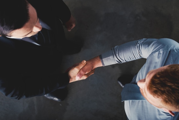 Homme d'affaires de poignée de main dans le concept de bureau de travail d'équipe et de partenariat