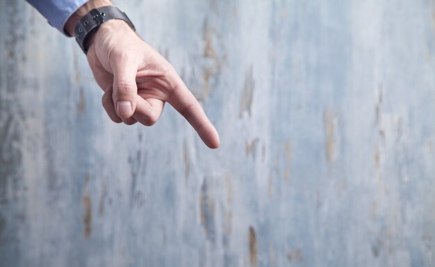 Homme d'affaires pointant le doigt sur un fond en bois bleu.