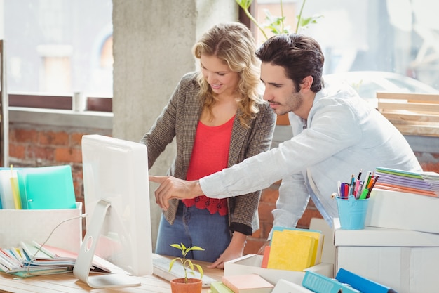 Homme d&#39;affaires pointant vers l&#39;ordinateur au bureau