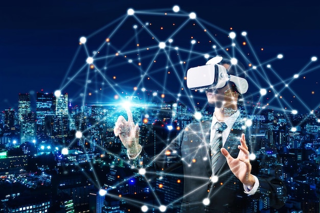 Homme d'affaires portant un casque de réalité virtuelle VR main touchant un écran virtuel lien global schéma de connexion sur fond de ville de nuit concept de communication internet numérique sécurité réseau