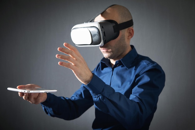 Homme d'affaires portant des lunettes de réalité virtuelle tenant une tablette numérique