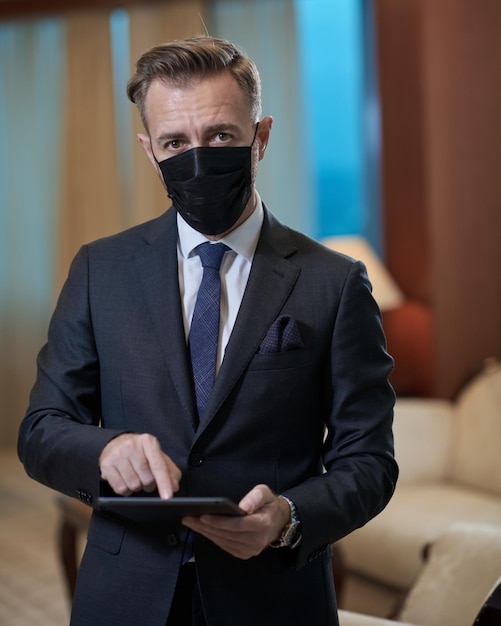 homme d'affaires portant un masque médical de protection au bureau de luxe