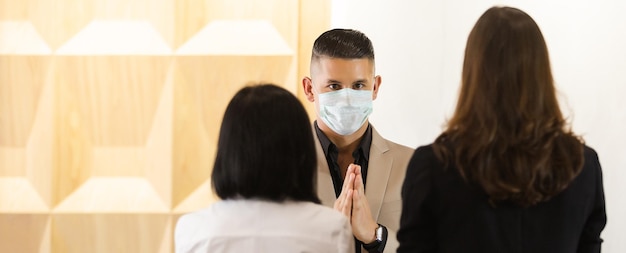 Homme d'affaires portant un masque médical saluant le style thaïlandais